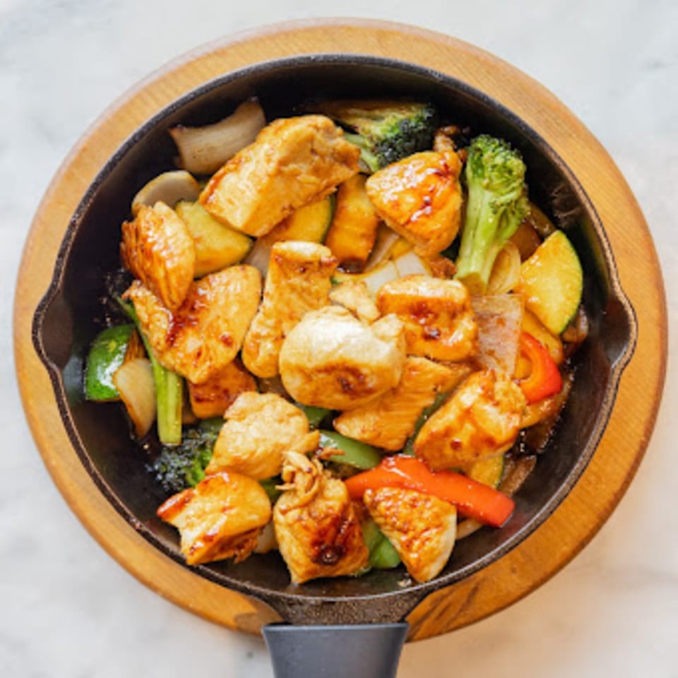 Miso's Japanese chicken and vegetable stir-fry in a sizzling cast iron pan.